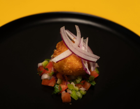 Croqueta gourmet sobre crema amarilla