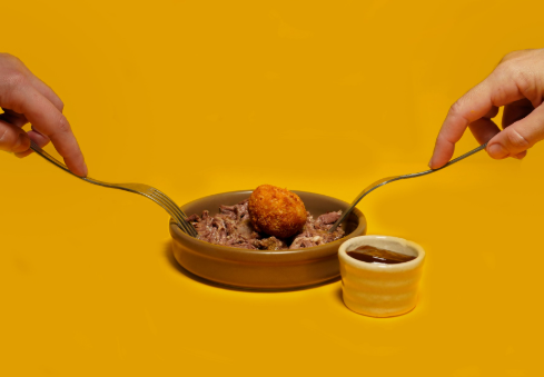 Croqueta con ingredientes y decoración gastronómica