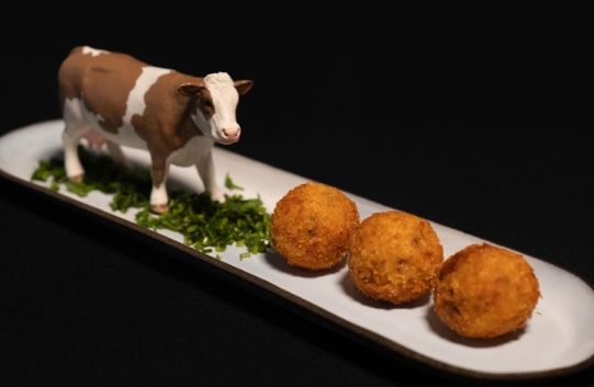 Croqueta servida con carne desmenuzada y salsa